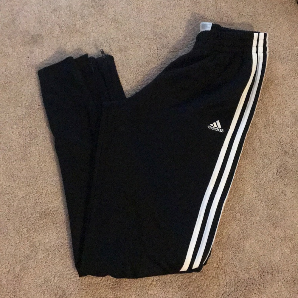 Black adidas pants with white stripes on the sides